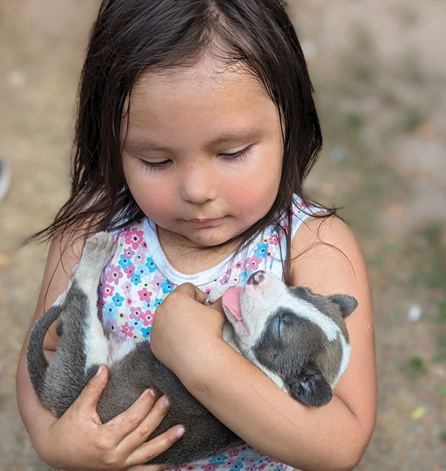 A child cradling her puppy