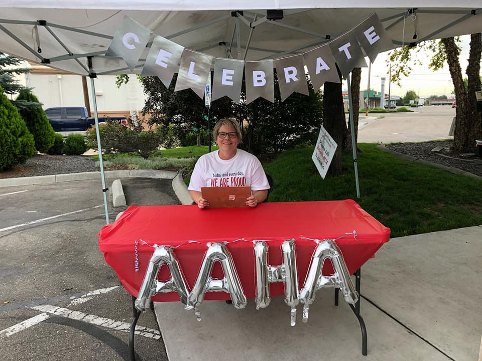 A team member greets guests at an outdoor celebration table at Idaho Veterinary Hospital.
