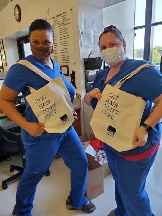 Team members at Skaer Veterinary Clinic in Wichita, Kansas, holding AAHA tote bags.