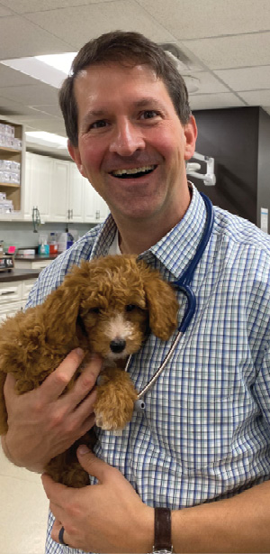 Andy Roark, DVM, MS in practice holding a puppy
