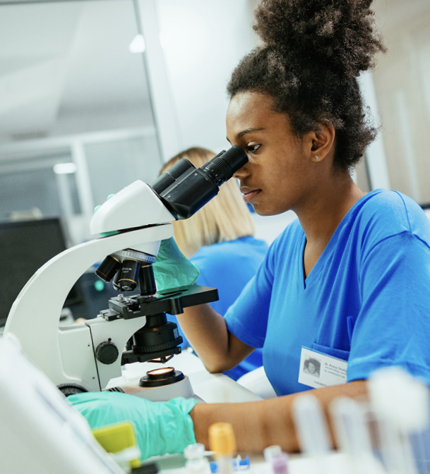 Technician looking through microscope