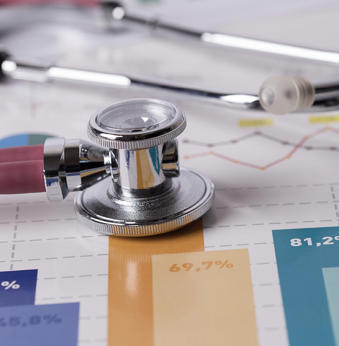 Financial graphs with a stethoscope laying on top