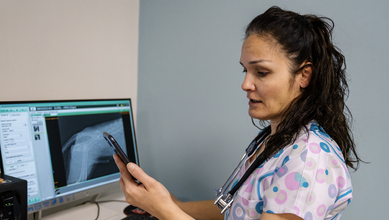 A technician collaborating with a specialist via phone for the care of a pet.