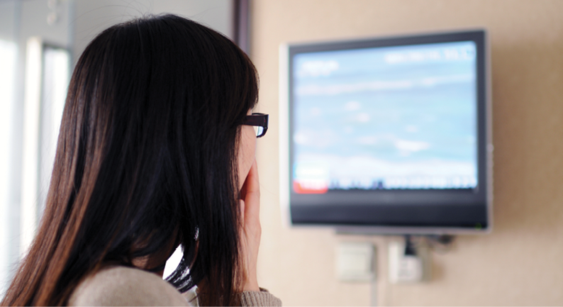 Woman watching tragedy unfold on the news