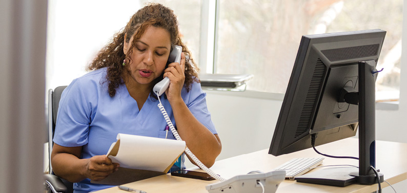 Veterinarian practicing collaborative care by going over patient record with a specialist via phone