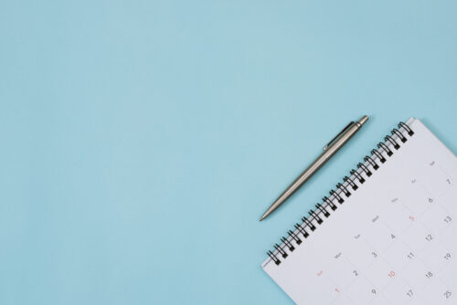 Calendar and pen on a blue background
