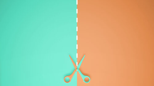 Scissors cut a piece of paper into one green side and one brown side