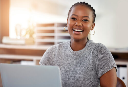 Woman using a laptop to pursue her career goals in veterinary technology through the flexible DEVTP online program.