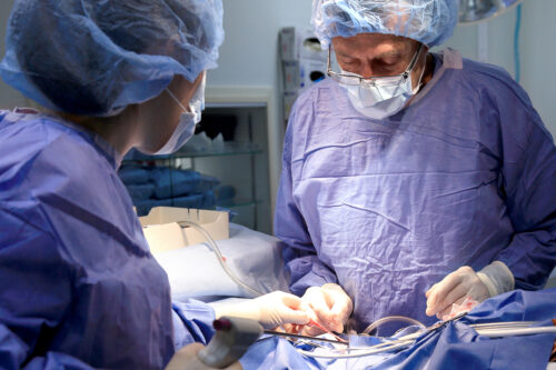 Two surgeons using a laser during surgery