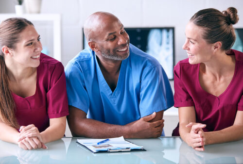 3 people in scrubs talking