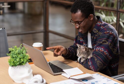 man on computer with cat
