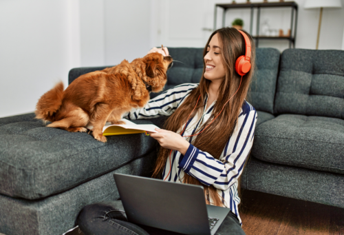 woman working on computer with dog helping