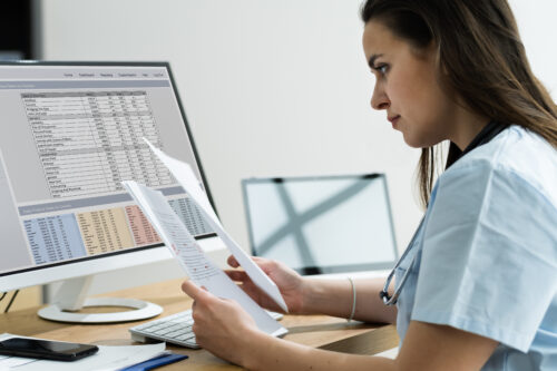 Female sitting at desk looking at invoices