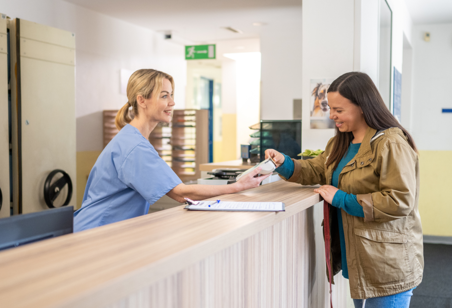 female receptionist at veterinary office accepts payment