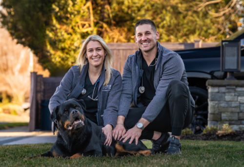 female veterinarian and male technician pose with Rottweiler