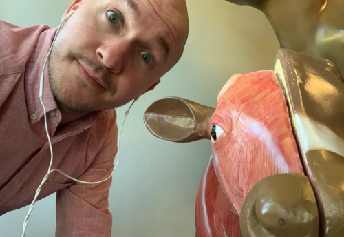 AAHA learning strategist, DJ Cannon, poses with a cow statue