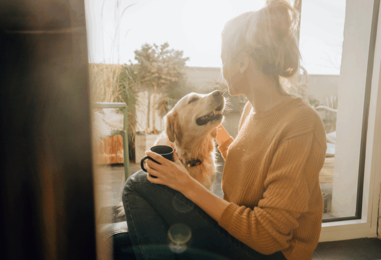 young woman drinks coffee with her dog