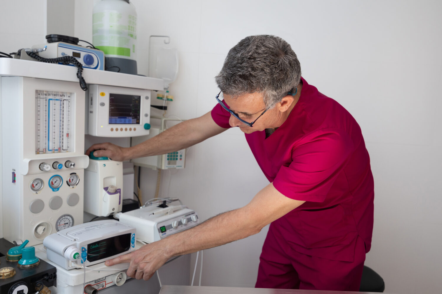 Veterinary professional calibrating anesthesia equipment before surgical procedure in modern clinic setting