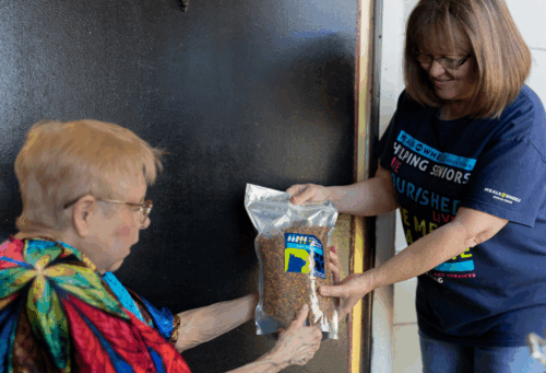 woman receives cat food from Meals on Wheels America
