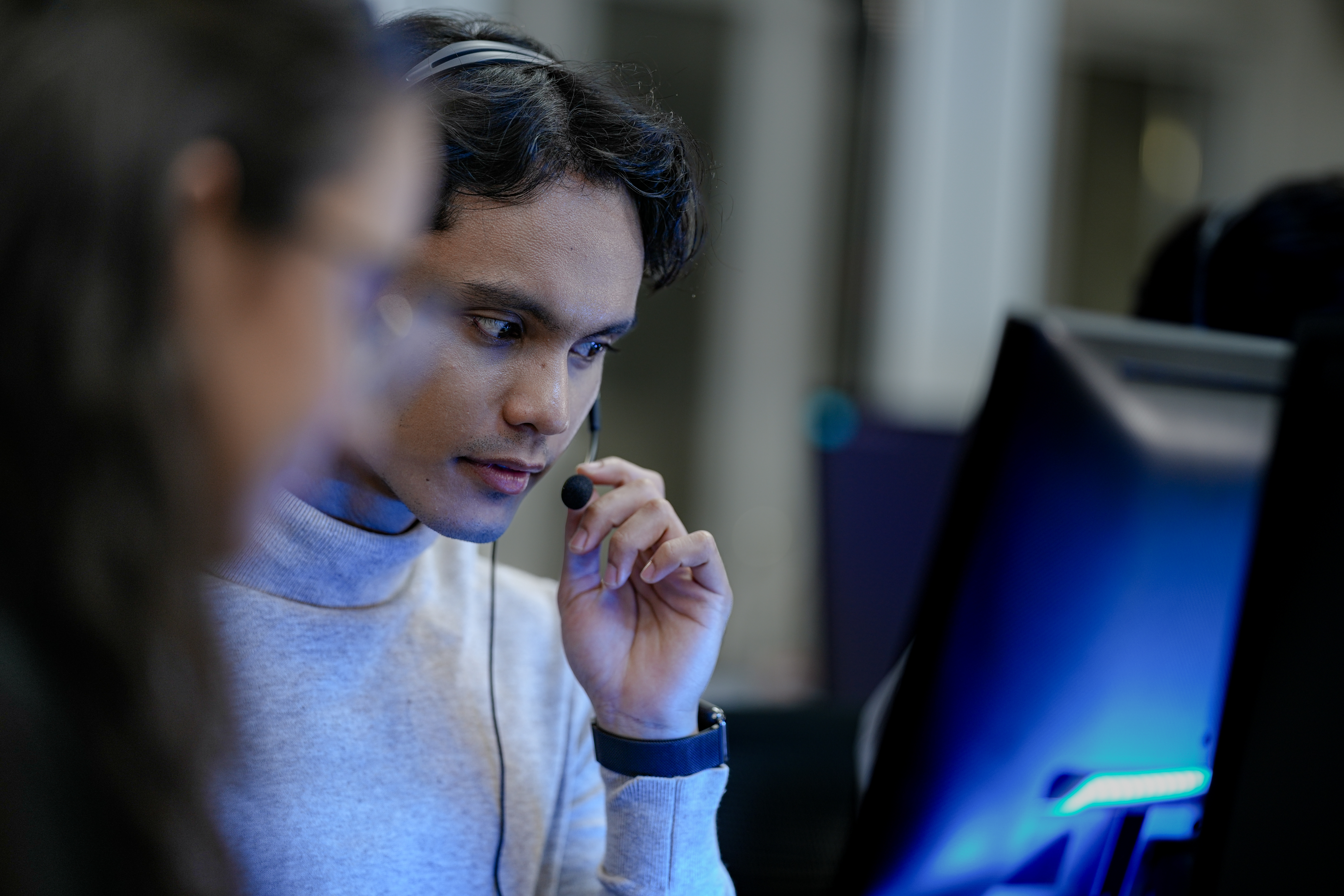Close-up of an intensely focused professional working as a technical support agent or a call center operator. He is deep in concentration, solving a complex problem for a client.