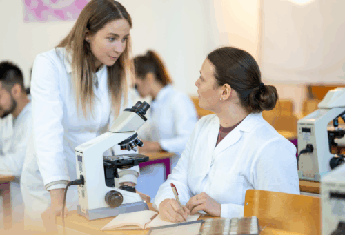 veterinary student and teacher with microscope