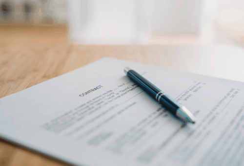 up close photo of a contract on a wooden table