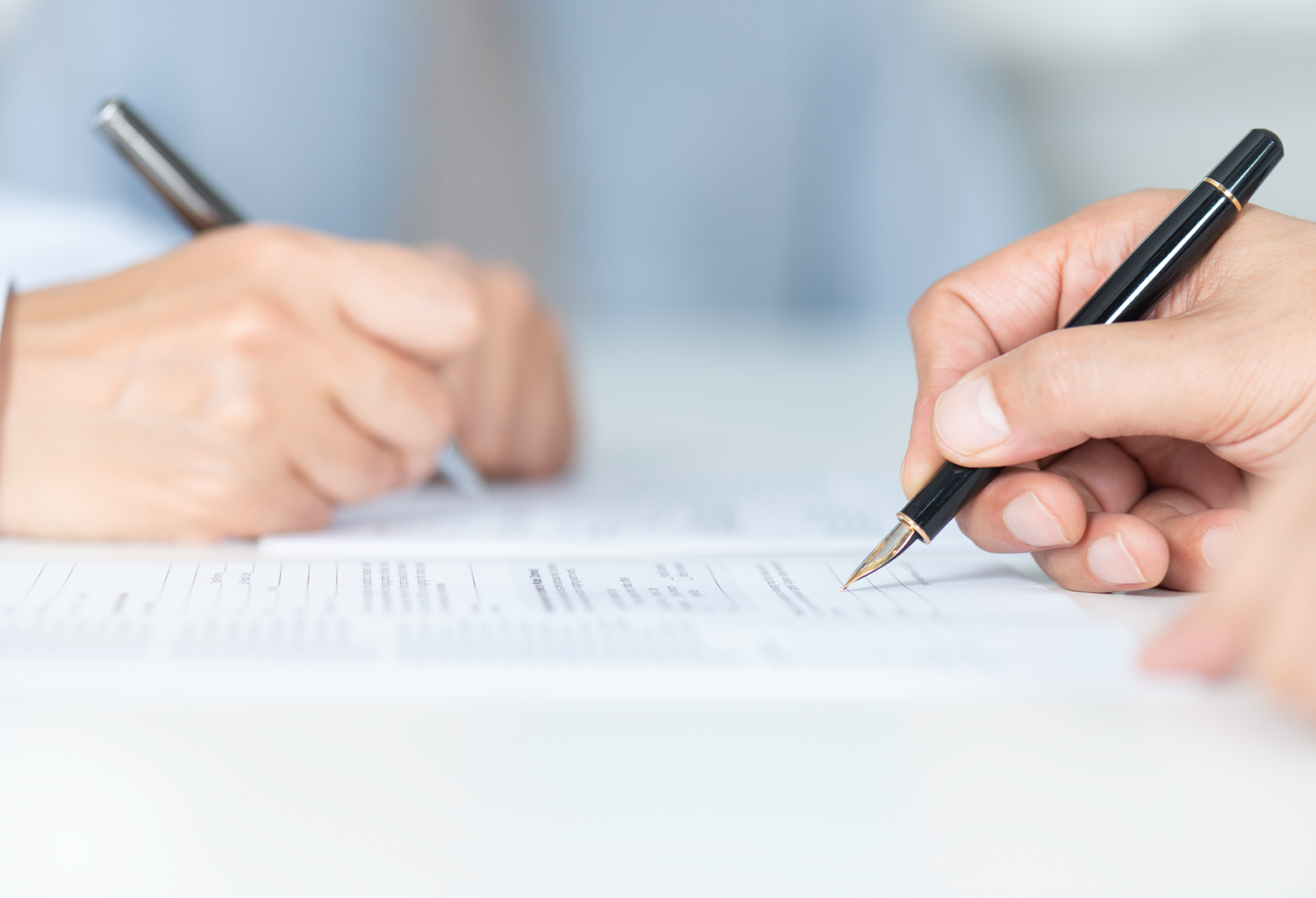 two people singning documents