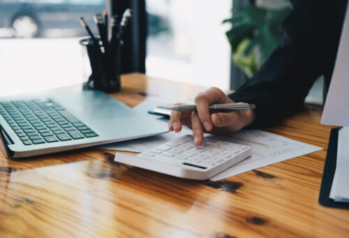 Close up an accountant working about financial with calculator at his office to calculate expenses, Accounting concept.