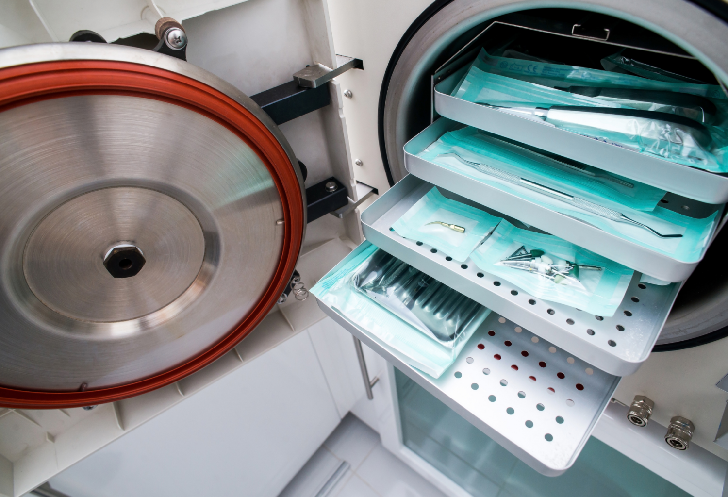 An autoclave with instruments in peel packs on trays inside